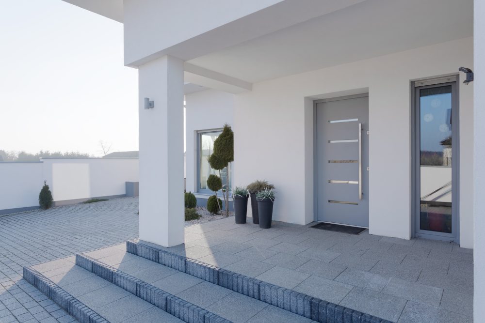 Feature front door in a grey colour with glass panels and side panel to allow for additional natural light to enter house.