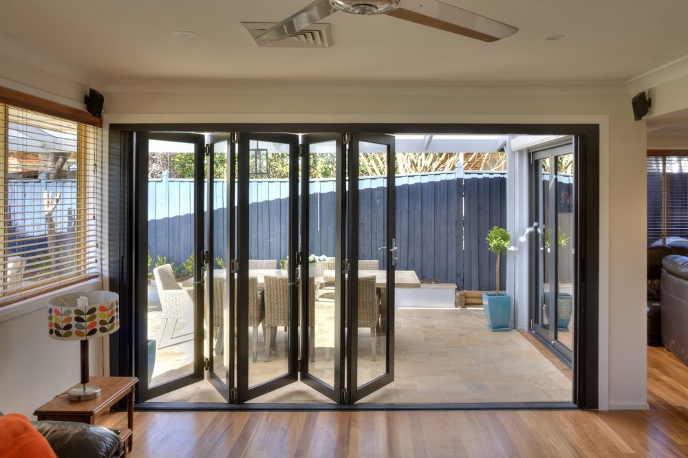 Black aluminium framed bi-fold doors opening to a patio.