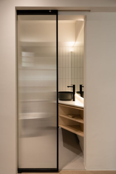 Corrugated sliding glass bathroom door.