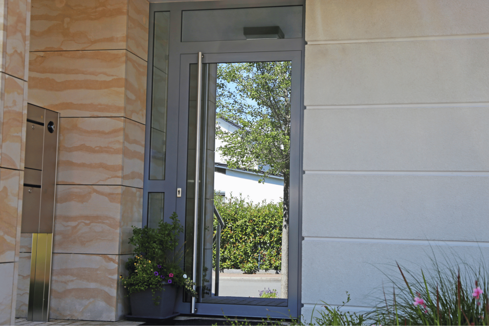 Glass front door with grey aluminium frame.